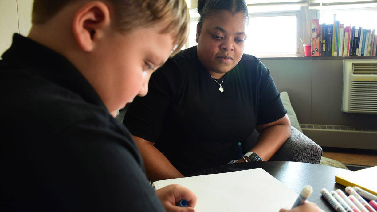 African American woman with boy who is coloring