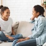 two people sitting on couch talking