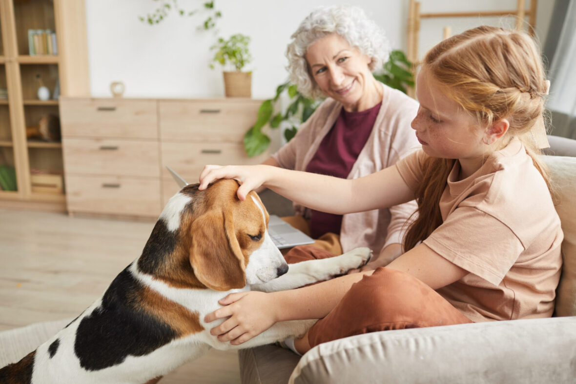 two people on couch with a dog